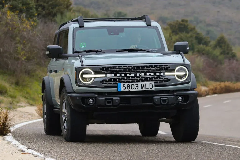 Ford Bronco Desert Rising Paket in einer Wüstenlandschaft geparkt, mit sichtbaren auffälligen magentafarbenen Außengrafiken