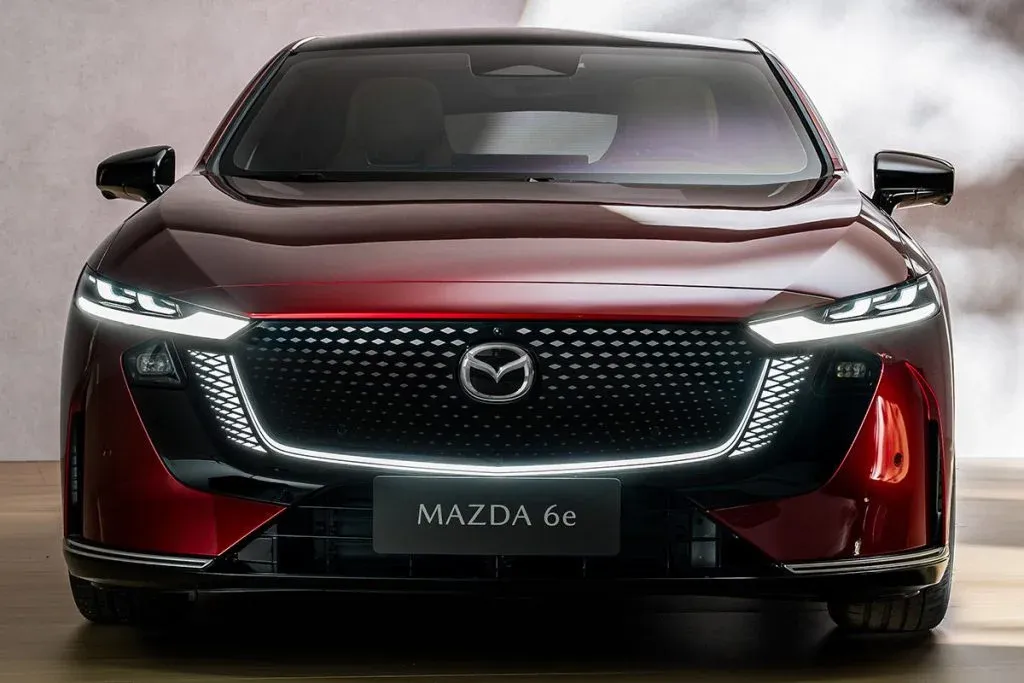 Mazda 6e und Tesla Model 3 bei einem Vergleichstest von Elektroautos auf einer Straße geparkt