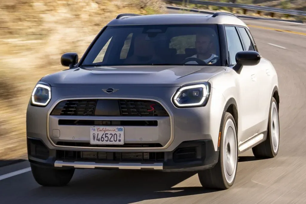 Getarnter Prototyp der MINI Countryman Edition bei Tests auf einer felsigen Bergstraße mit Offroad-Reifen und Dachzelt
