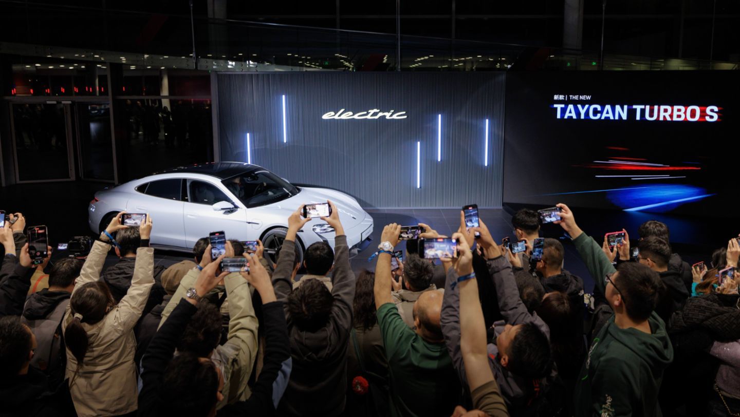 Porsche Taycan und ein Elektroauto von Xpeng stehen auf einer europäischen Stadtstraße nebeneinander